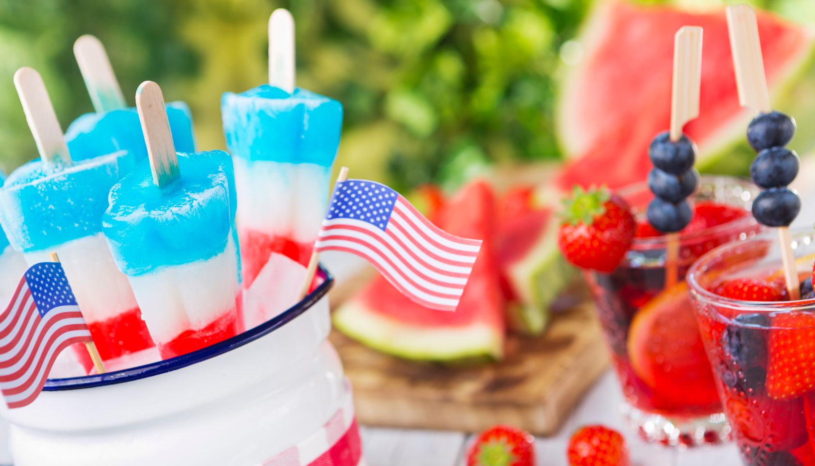 Homemade red-white-and-blue popsicles on an outdoor table.