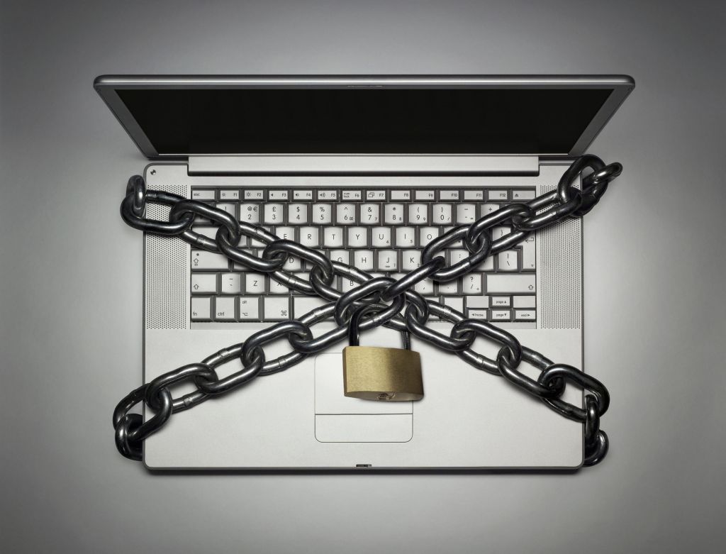 Laptop locked with chain, close-up, overhead view, (digital composite)
