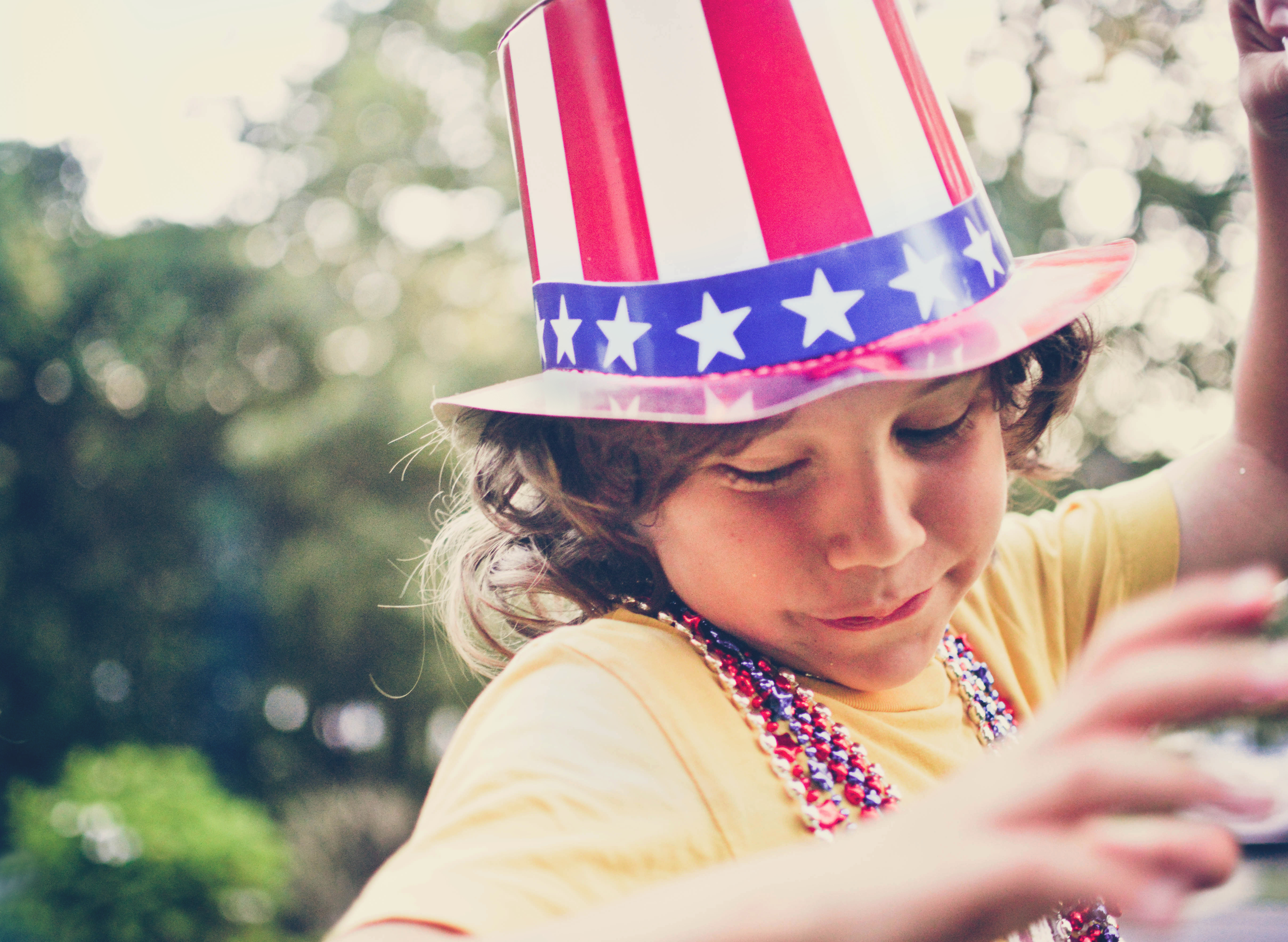 Patriotic boy wearing a hat and beads.