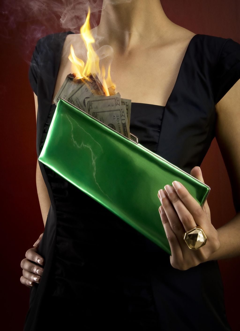 Woman holding pocketbook with money on fire