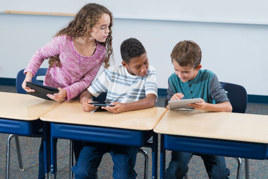 Three elementary school students, digital tablets