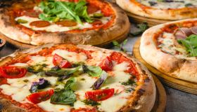 Top view of various neapolitan pizzas on grey stone table