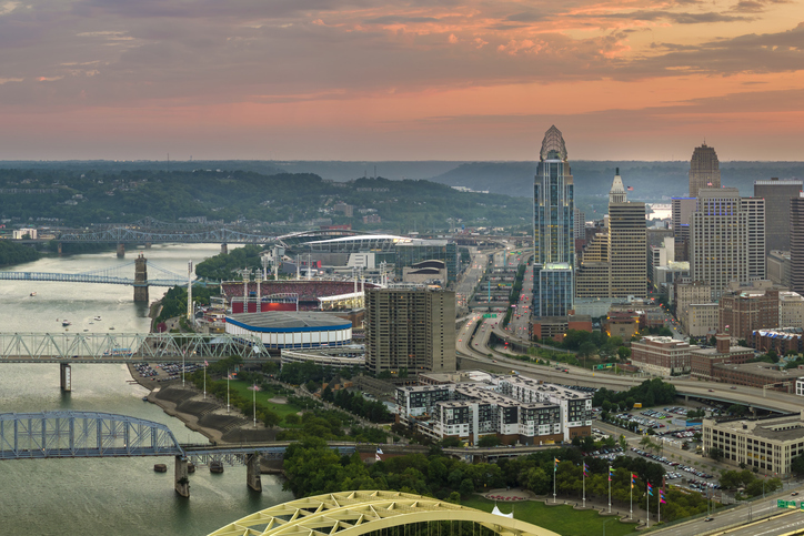 Cincinnati city in state of Ohio with brightly illuminated high skyscraper buildings in downtown district. American megapolis with business financial district at sunset