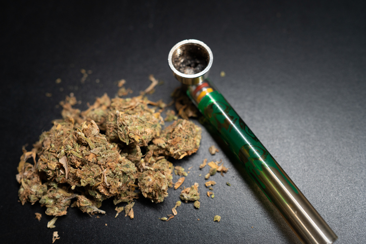 Cannabis and Bong Displayed on a Dark Surface Showcasing a Relaxing Atmosphere