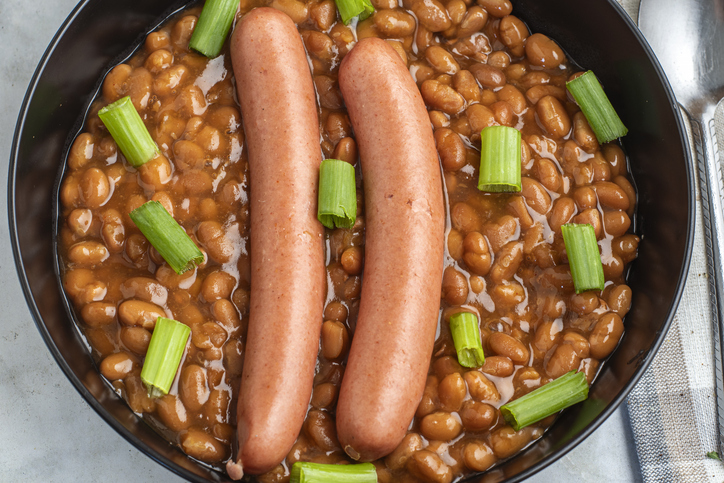 hot dogs on baked beans top with green onions