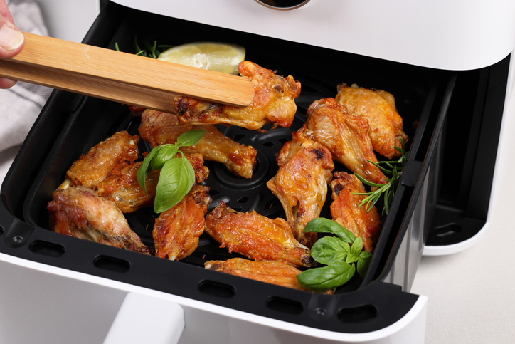 Air Fryer with chicken drumsticks and wings