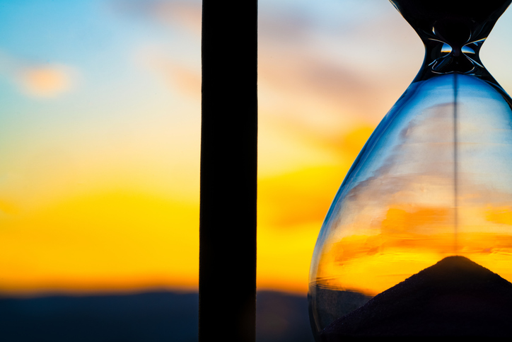 Hourglass and city at sunset