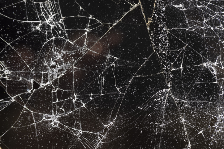 broken glass on a black background, glass broken into many pieces, closeup