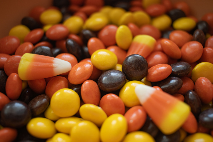 Heap of the autumn-colored round Reese Pieces and corn-like candies filled without packets