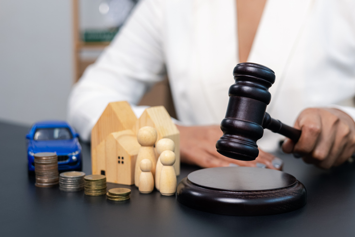 Judge hitting gavel with house family car and coins on table, legal decision and property concept