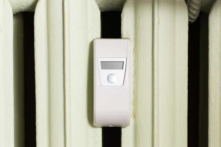 Heat cost allocator on radiator measuring heating consumption. Energy usage meter in apartment.