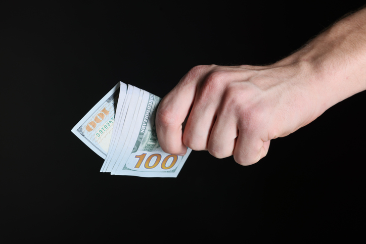 Man with dollar banknotes on black background, closeup