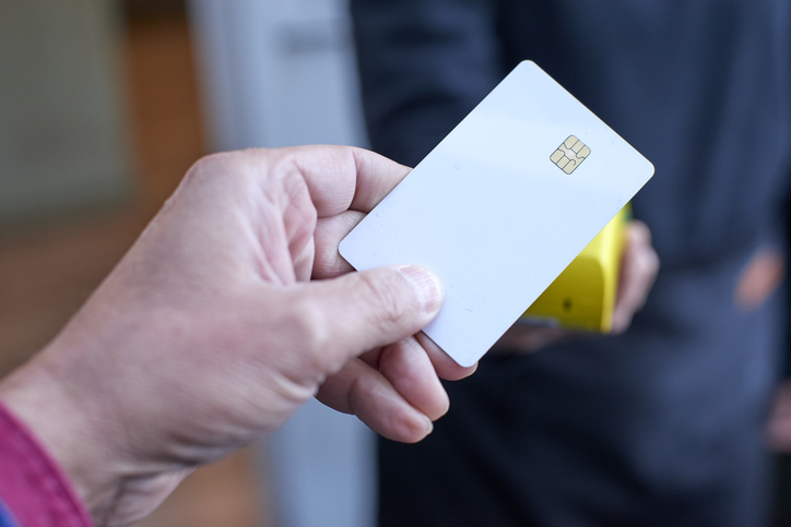 Hand using a credit card for contactless payment