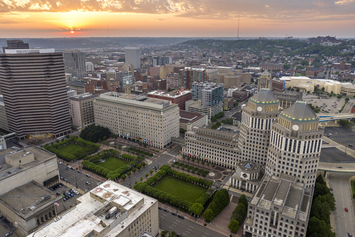 Cincinnati city, Ohio USA. View from above of brightly illuminated high skyscraper buildings in downtown district of American megapolis with business financial district at sunset
