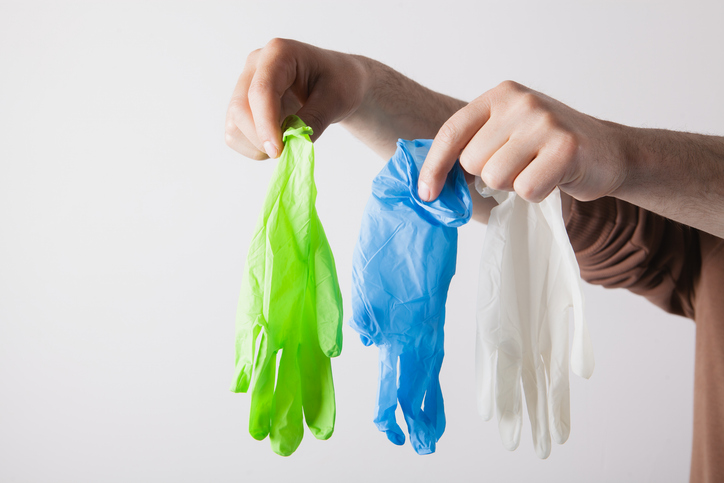 Male hands holding medical gloves on a white background. Close-up.