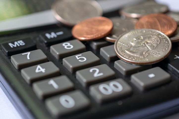 Financial Planning And Budgeting: Us Coins On Calculator For Expense Management.