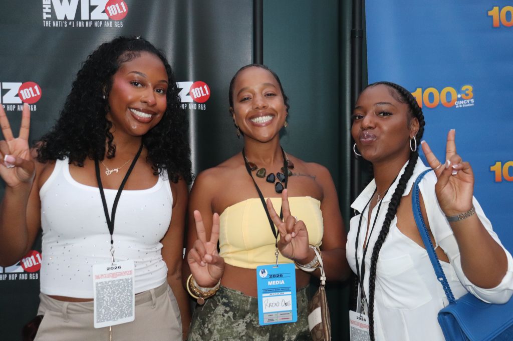 Three smiling women making peace signs at a media event for "The Wiz 2011" hip hop and R&B festival.